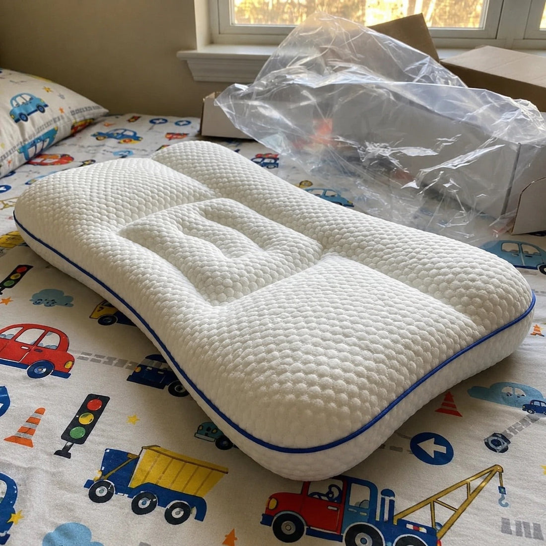 Oreiller ergonomique enfant Lymphelia sur un lit d'enfant