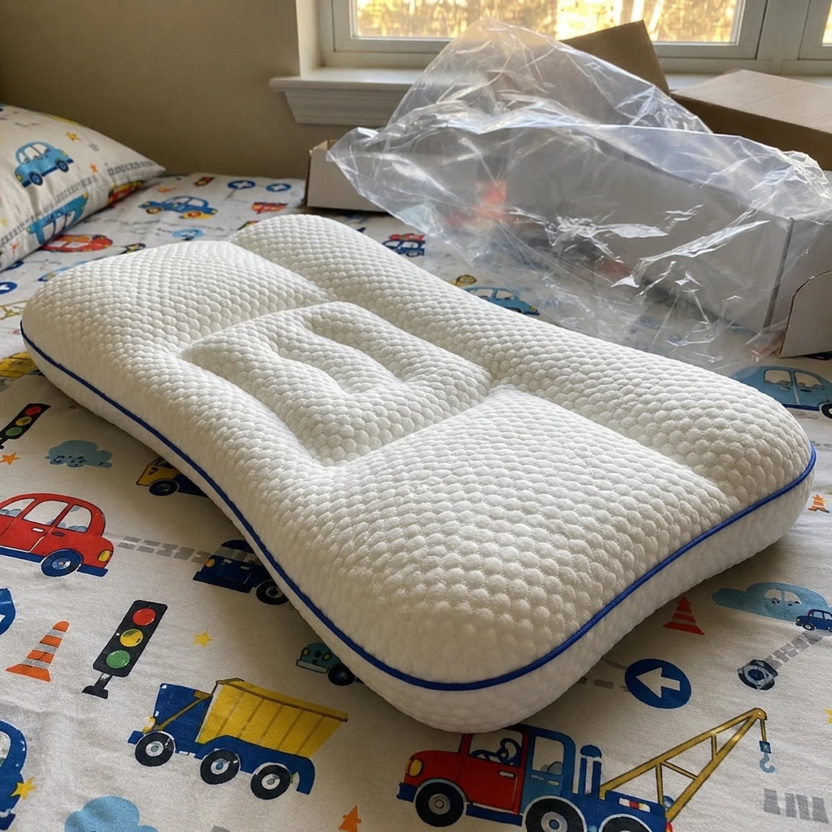 Oreiller ergonomique enfant Lymphelia sur un lit d'enfant